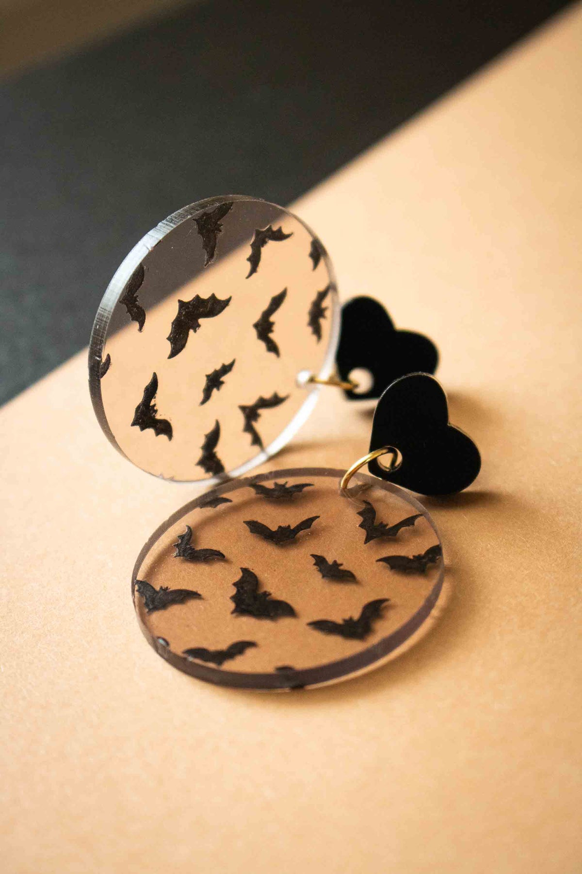 Boucles d’oreilles transparentes à chauves-souris noires photographiées de côté