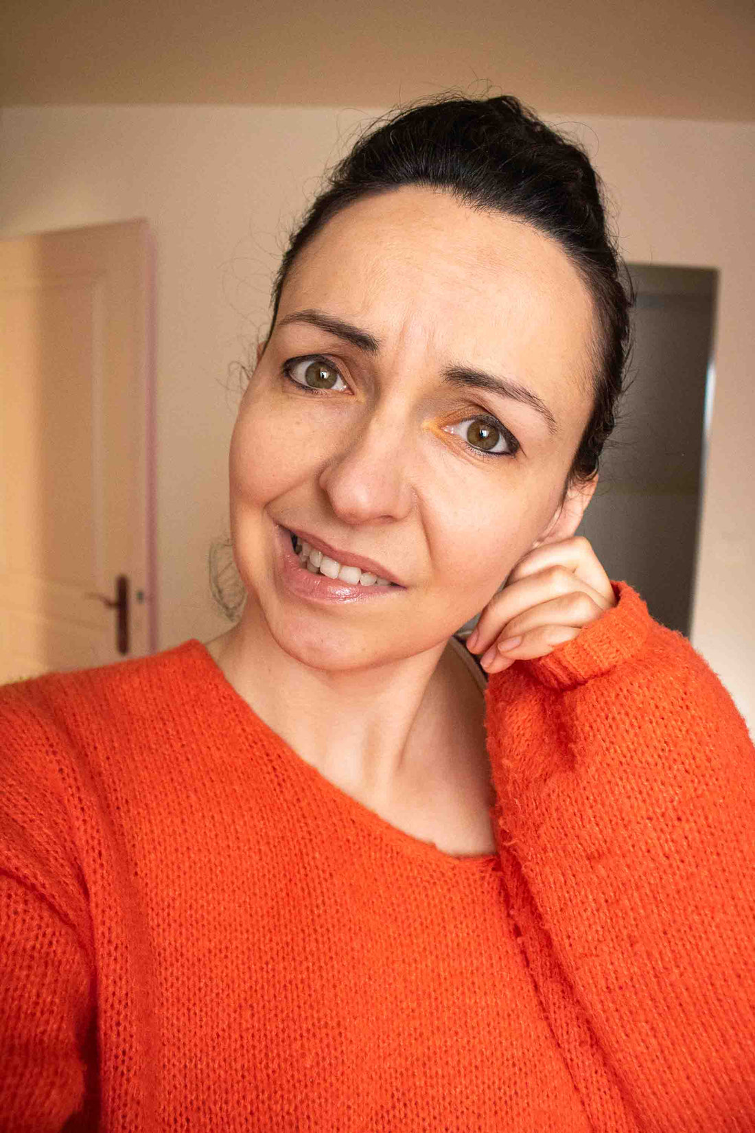 Femme se grattant l'oreille après avoir porté des boucles d'oreilles inconfortables — illustration des oreilles sensibles et douleurs liées aux bijoux lourds