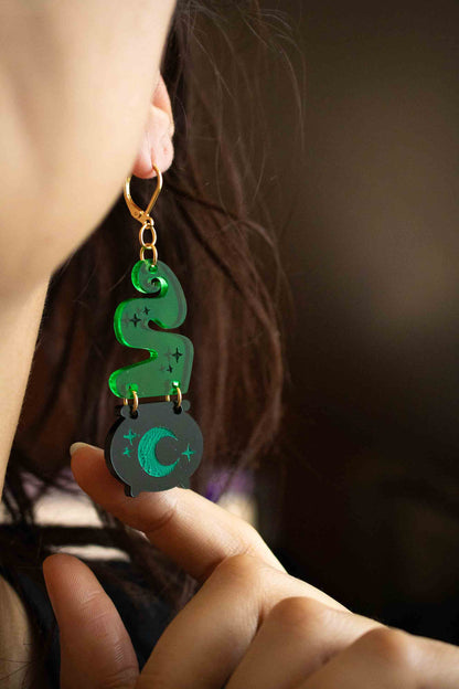Boucle d’oreille pendante chaudron magique portée, avec fumée verte, lune et dormeuse dorée
