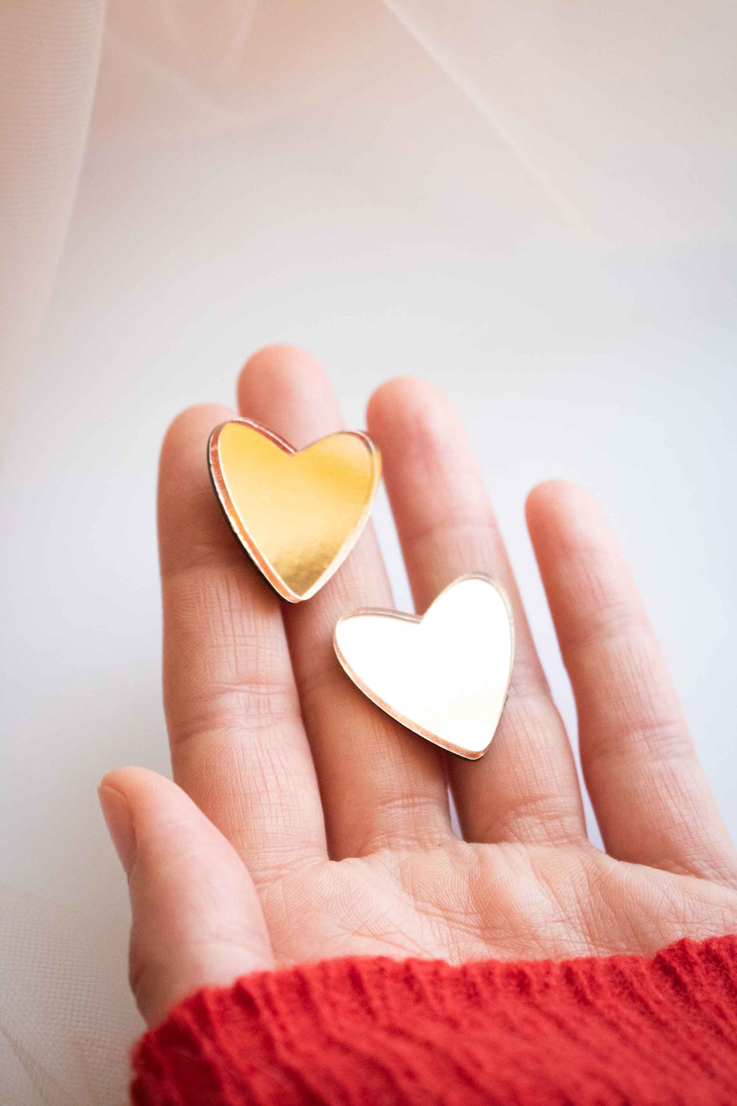 boucles d'oreille cœur rose gold miroir posées sur une main, Limonade Studio