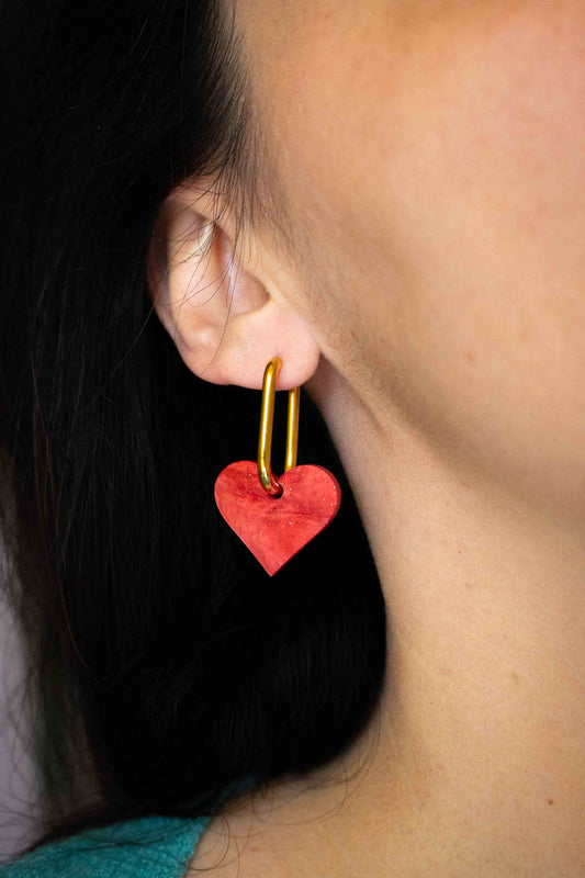 Boucle d'oreille cœur rouge acrylique pailleté Limonade Studio portée à l'oreille, bijou artisanal fait main cadeau femme, gros plan profil