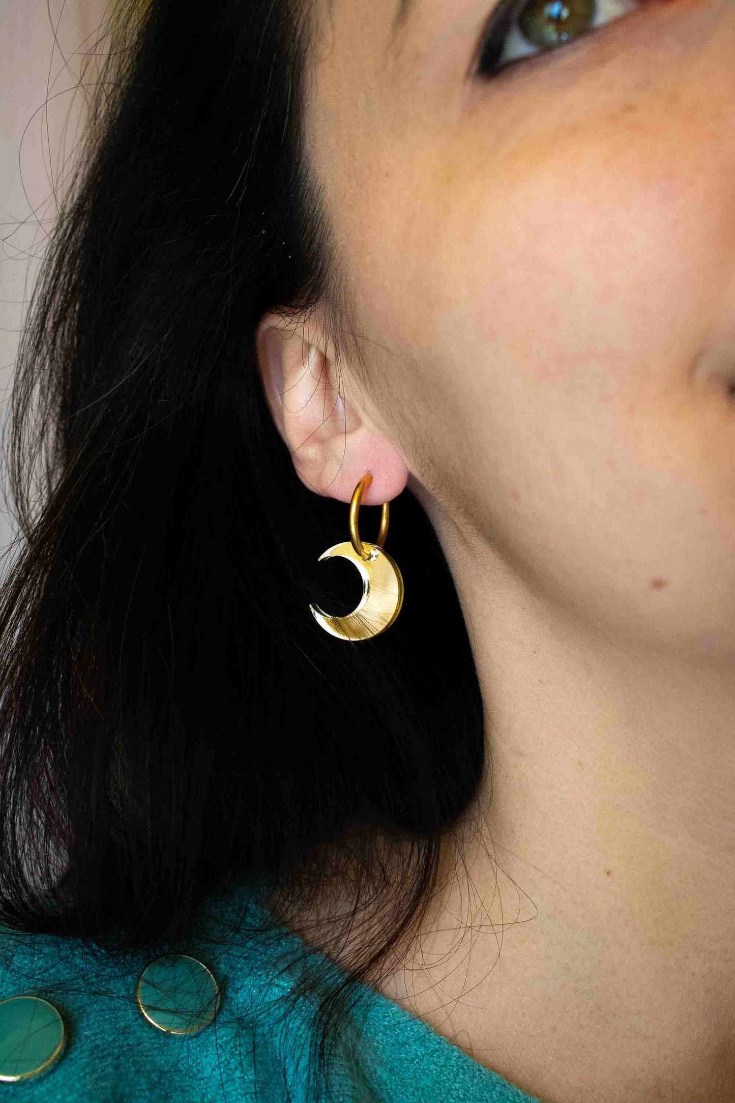 Boucle d'oreille huggies dorée avec lune acrylique miroir portée sur oreille, bijou artisanal cadeau femme Limonade Studio, gros plan profil