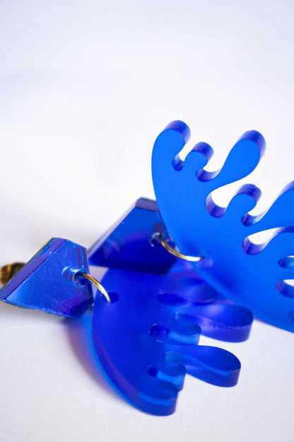 Gros plan sur la découpe laser des boucles d'oreilles bleues acrylique, détail organique et anneau doré, bijou artisanal Limonade Studio