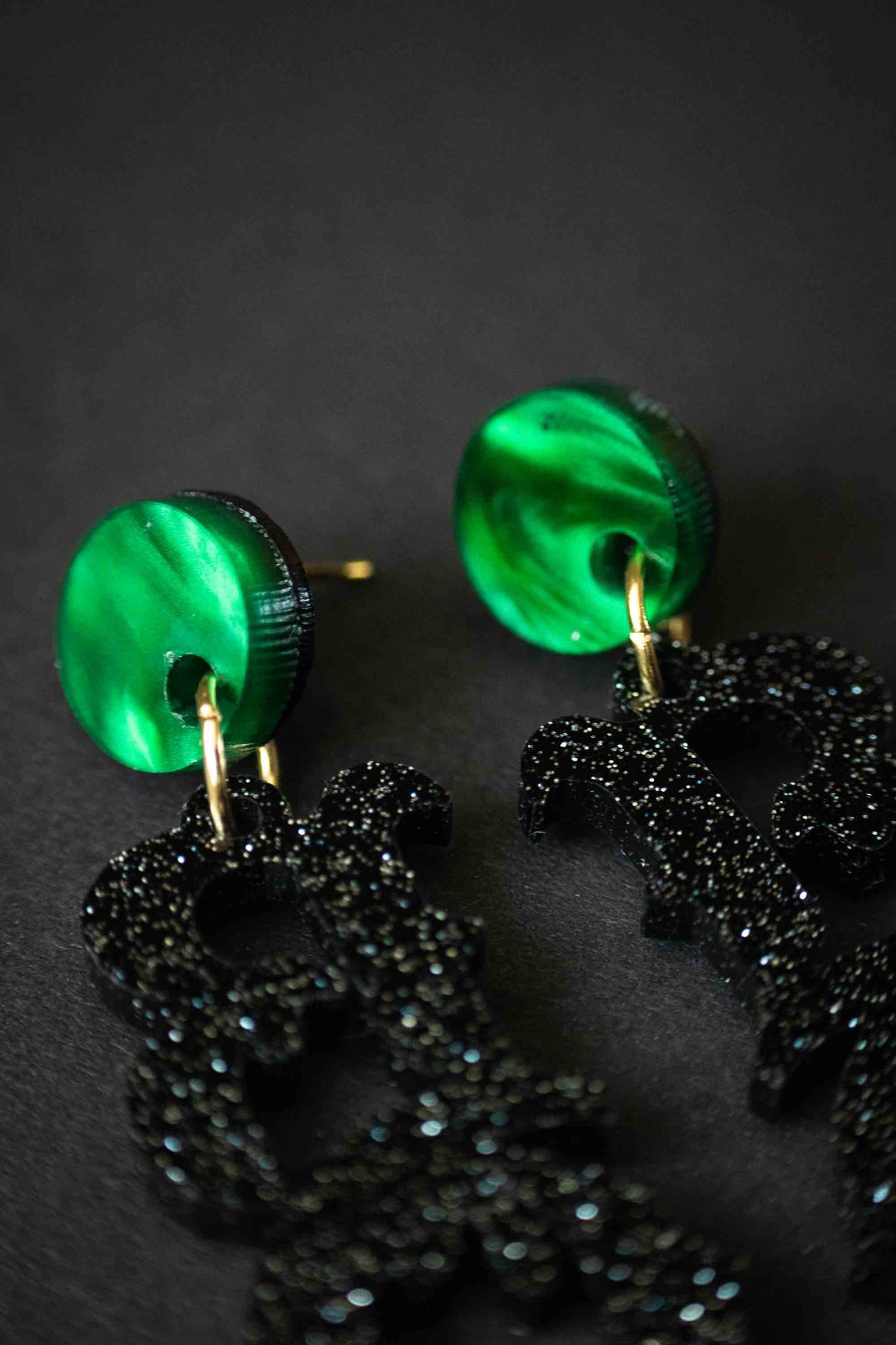 Détail des puces rondes vertes des boucles d’oreilles BOO