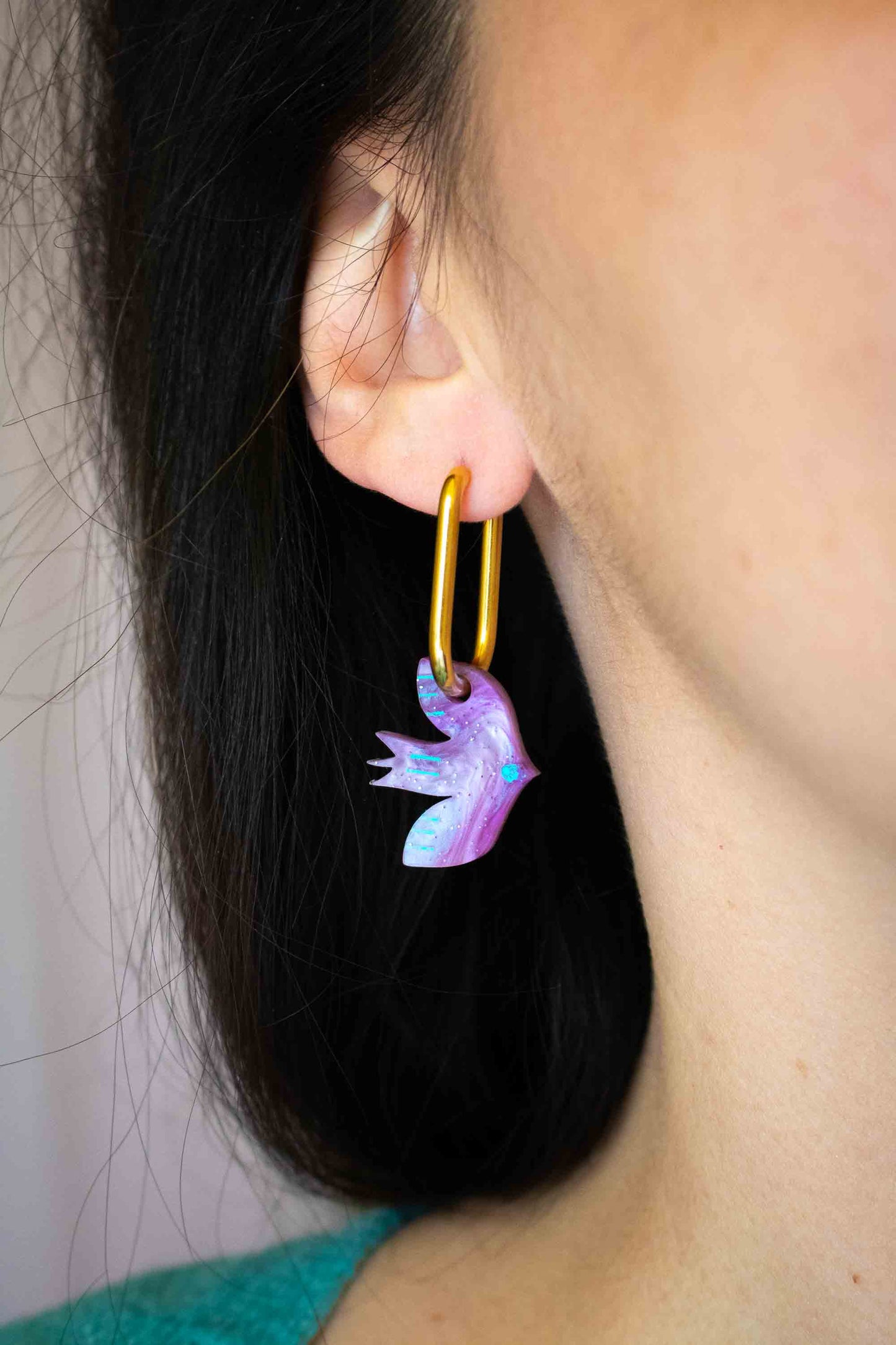 Boucle d'oreille huggies oiseau violet acrylique marbré, anneau acier doré, bijou coloré artisanal Limonade Studio, portée vue de profil