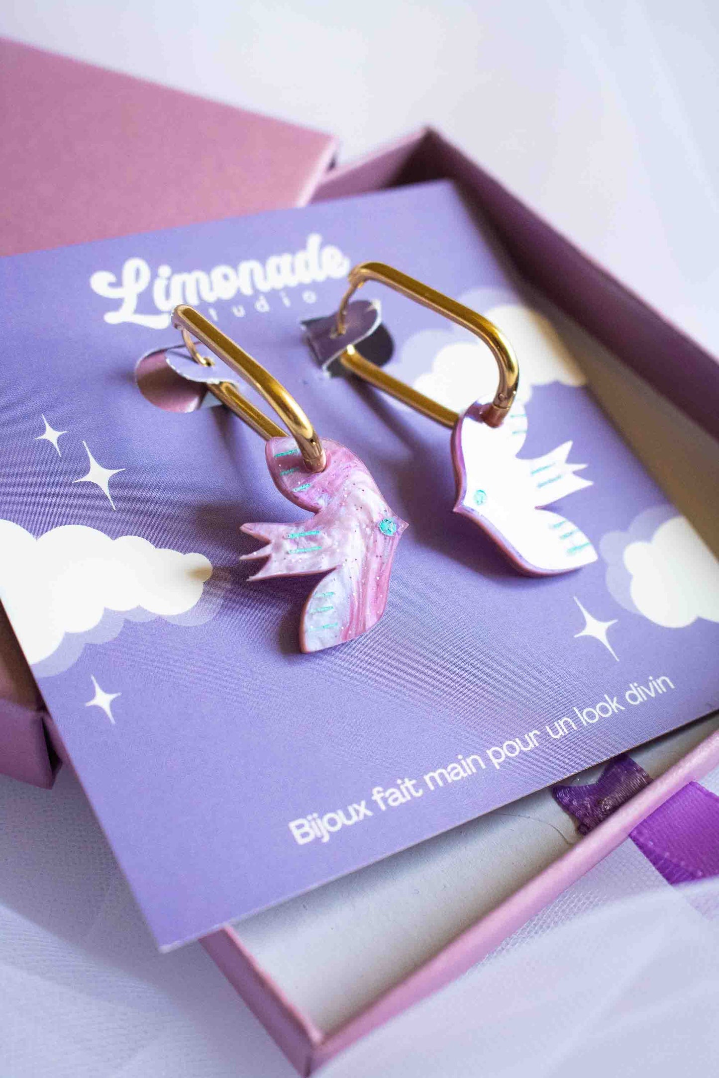 Boucles d'oreilles huggies oiseau violet acrylique, cadeau original fait main Limonade Studio, présentées dans boîte cadeau violette ouverte