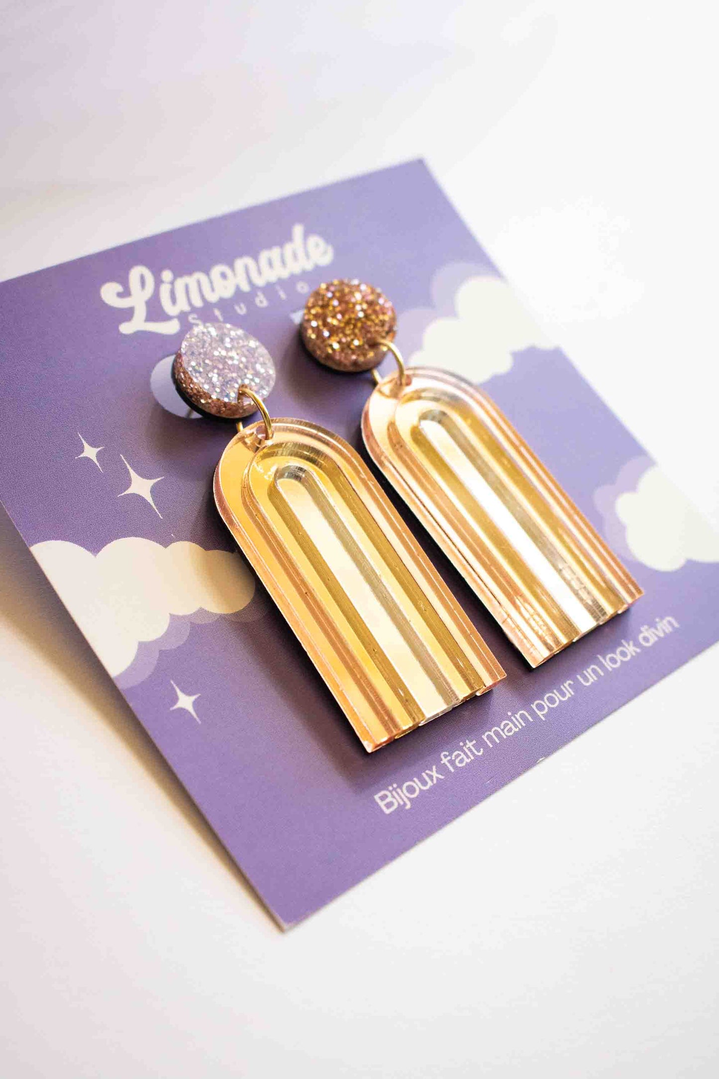 Boucles d'oreilles pendantes arche or miroir en acrylique découpé au laser, bijou créateur fait main, Limonade Studio, sur cartonnette vue inclinée
