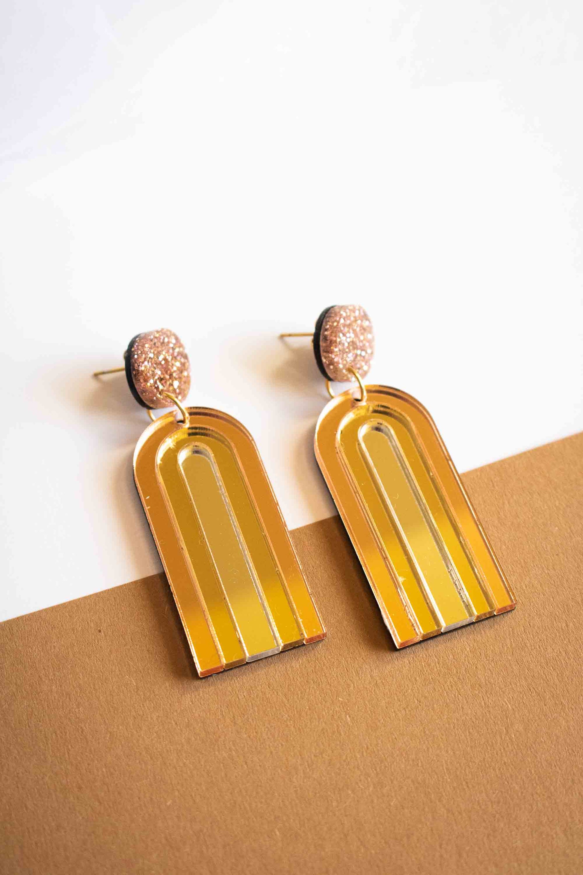 Paire de boucles d'oreilles pendantes arche or miroir brillant, acrylique découpé au laser, cadeau femme artisanal, Limonade Studio, sur fond caramel