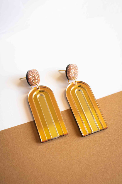 Paire de boucles d'oreilles pendantes arche or miroir brillant, acrylique découpé au laser, cadeau femme artisanal, Limonade Studio, sur fond caramel