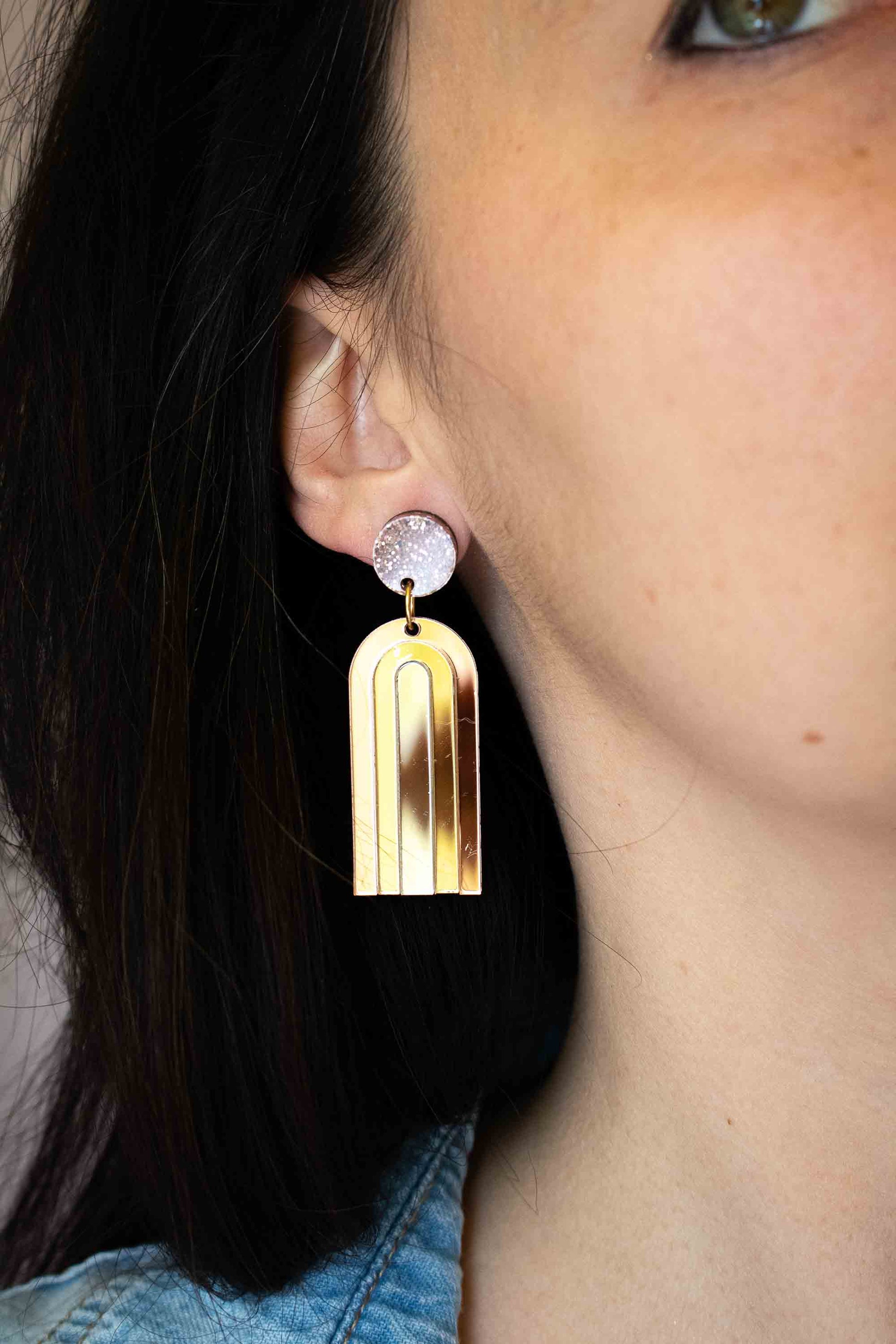 Boucles d'oreilles pendantes arche or miroir en acrylique découpé au laser, puce pailletée argent, fait main par Limonade Studio, portées de profil