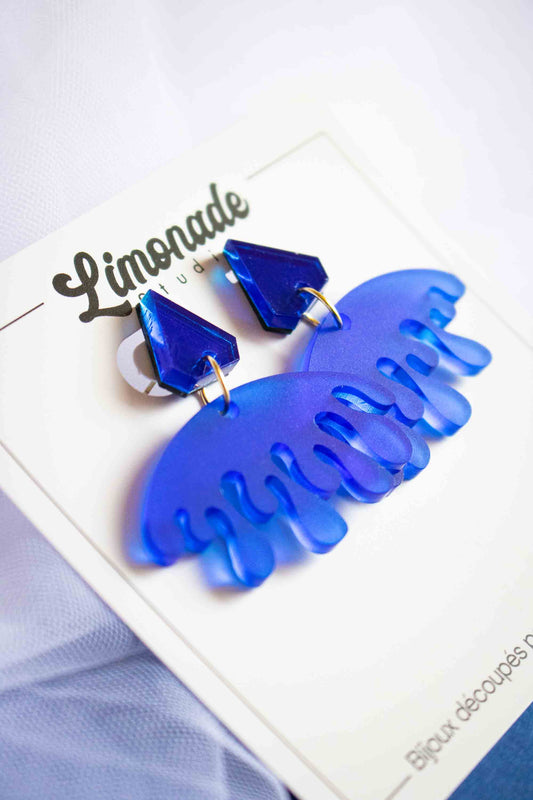 Boucles d'oreilles pendantes bleues acrylique miroir et dépoli, bijou coloré fait main, Limonade Studio, présentées sur packaging