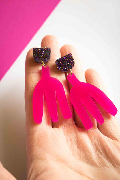 Boucles d'oreilles pendantes fuchsia en acrylique découpé au laser tenues dans la paume, clou pailleté holographique, bijoux faits main Limonade Studio