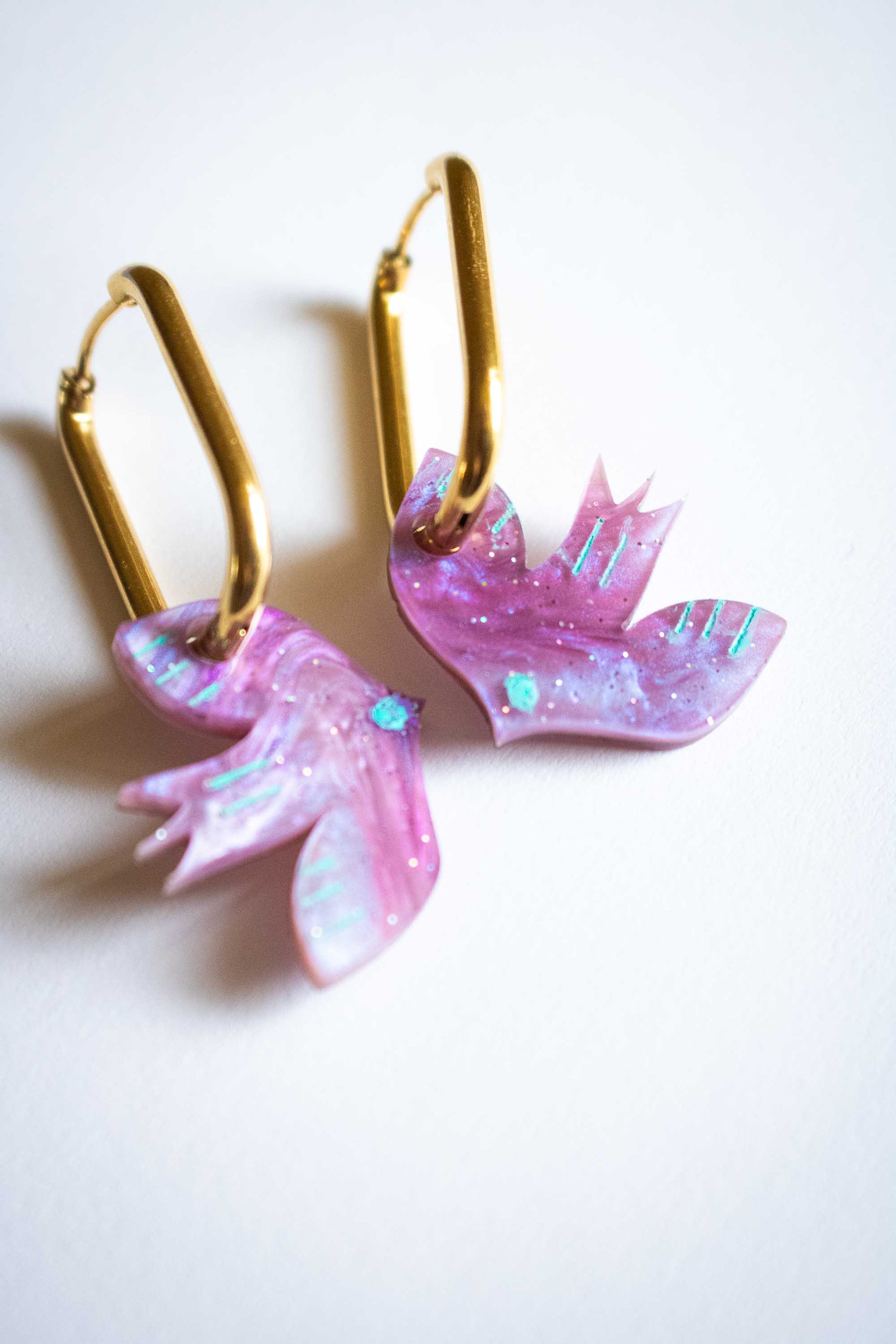 Boucles d'oreilles pendantes oiseau violet géométrique en acrylique, détails turquoise, cadeau femme fait main Limonade Studio, sur fond blanc
