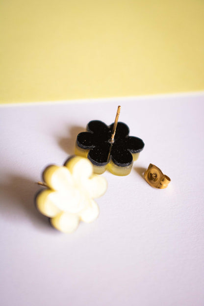 Détail du dos des boucles d'oreilles puces fleur jaune acrylique, tige et poussette dorées en acier inoxydable