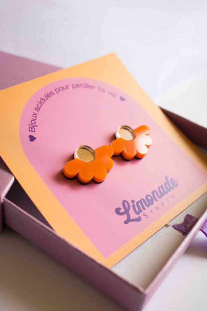 Gros plan sur la cartonnette Limonade Studio dans la boîte cadeau rose, puces fleur orange acrylique miroir doré