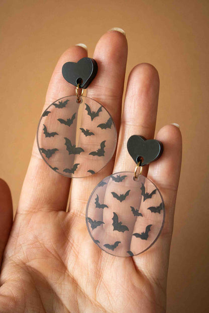 Boucles d’oreilles rondes chauves-souris présentées dans une main pour montrer leur taille