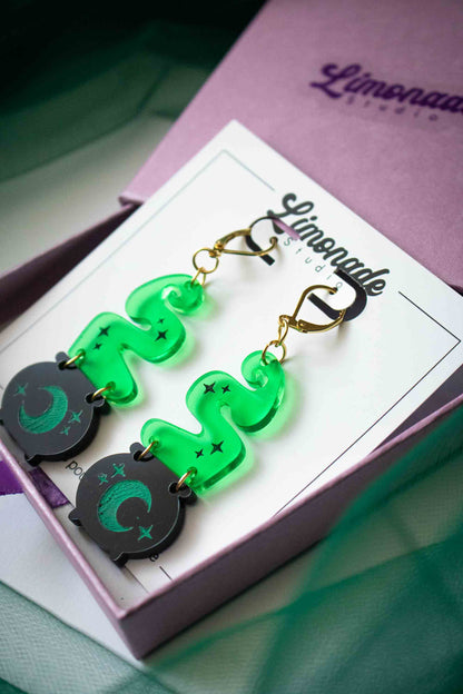 Boucles d’oreilles chaudron et fumée verte présentées dans leur écrin rose avec carte de bijou