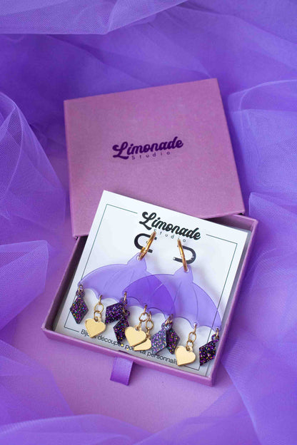 boucles d’oreilles violettes en acrylique decoupe laser, cadeau original Limonade Studio, presentees dans un packaging d emballage violet.
