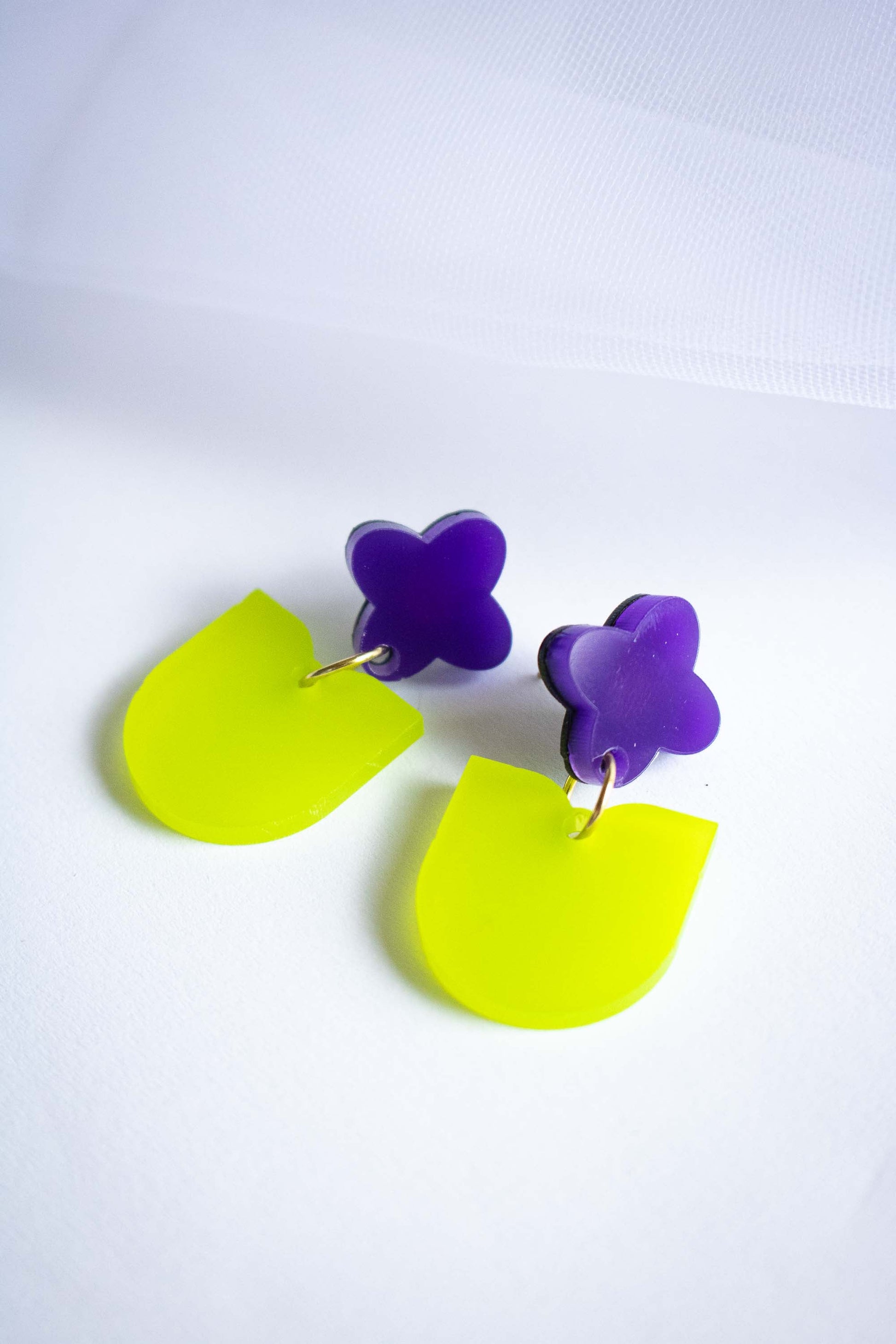 Paire de boucles pendantes fleur violette et vert acrylique, createur francais Limonade Studio, vue de face sur fond blanc