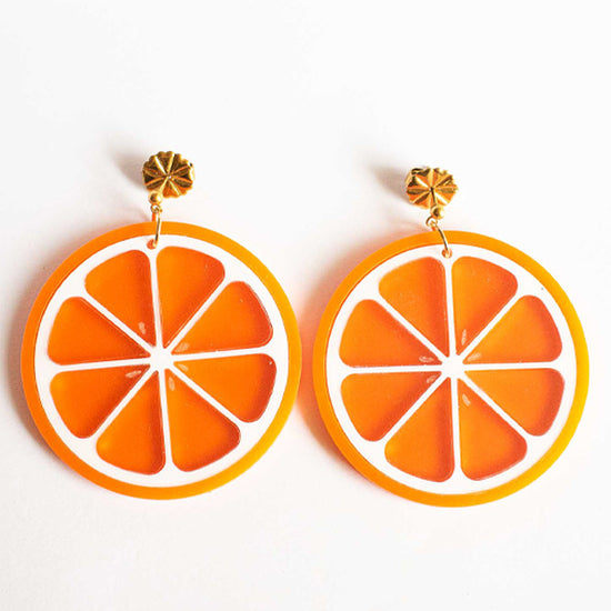 Vidéo de boucles d'oreille découpées au laser de Limonade studio en forme d'orange acidulée, montrées porté et sur packaging