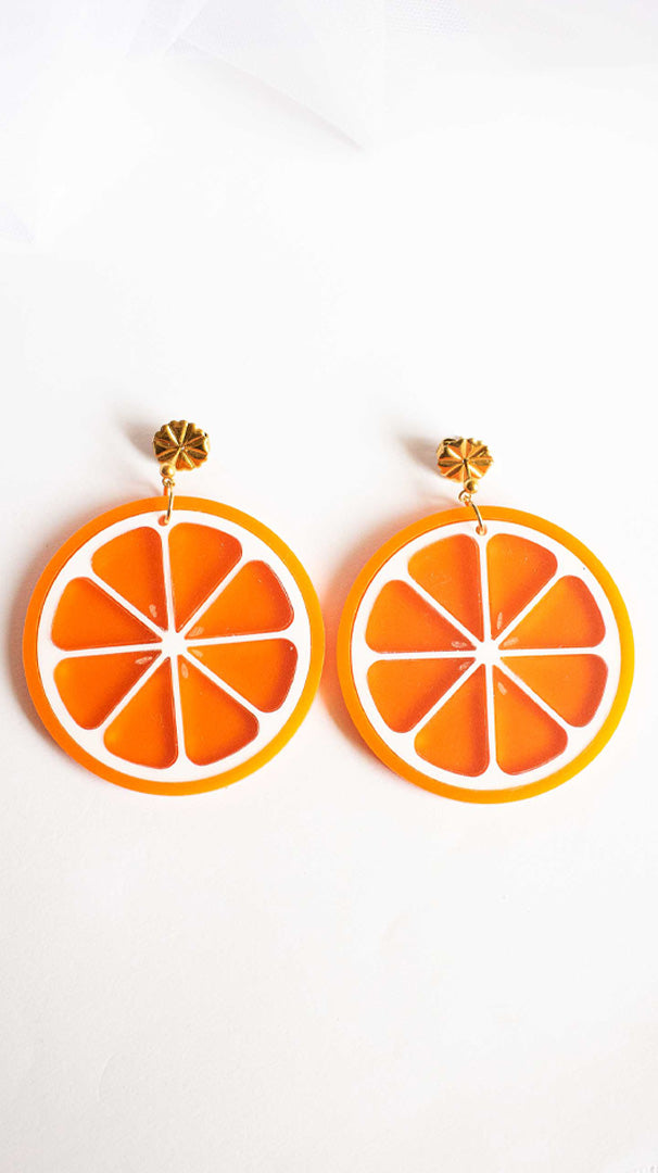 Vidéo de boucles d'oreille découpées au laser de Limonade studio en forme d'orange acidulée, montrées porté et sur packaging