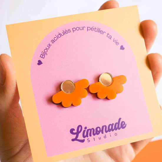 Vidéo des boucles d'oreilles puces fleur orange en acrylique découpé au laser Limonade Studio : vue portée puis présentées sur leur cartonnette d'emballage, bijoux faits main colorés