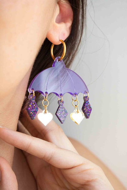 Boucles d oreilles violettes en acrylique découpe laser, bijou colore artisanal Limonade Studio, portée sur modèles, pampilles en mouvement et montré sur packaging.